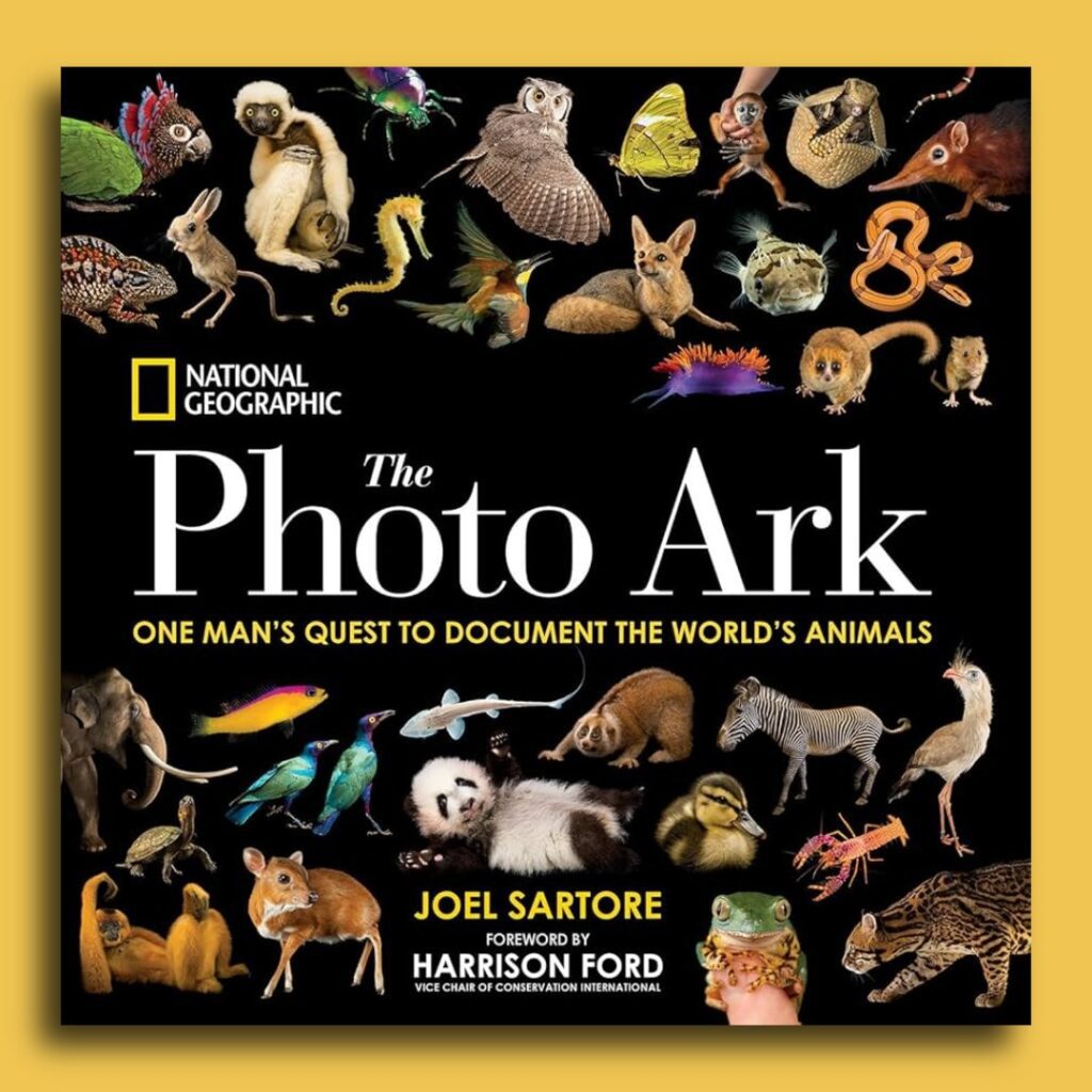 Book review image of the book cover for The Photo Ark: One Man’s Quest to Document the World’s Animals (2017), a nonfiction conservation photography book by Joel Sartore. The cover displays studio portraits of diverse animal species against a black background, emphasizing biodiversity, individuality, and extinction awareness.
